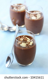 Delicious chocolate mousse in dessert glasses, on pastel blue napkin.