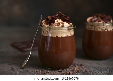 Delicious Chocolate Mousse Or Pudding With Whipped Cream In A Vintage Glass Jar On A Dark Slate, Stone Or Concrete Background.