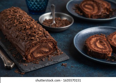 delicious chocolate roll cake with chocolate cream, dark blue background. selective focus - Shutterstock ID 1635570151