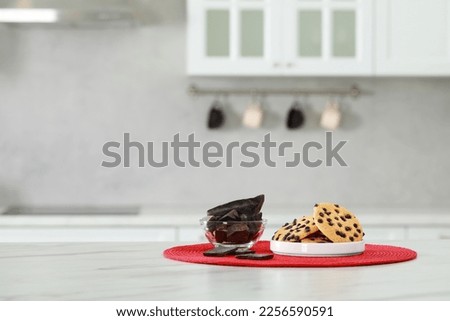 Delicious chocolate and tasty cookies on white marble table in kitchen. Space for text