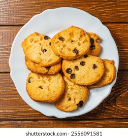 Delicious Christmas cookies with raisins on a white plate on a wooden table - Powered by Shutterstock