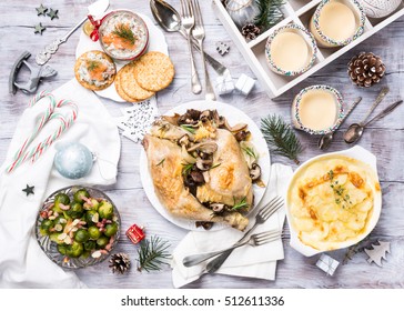 Delicious Christmas Themed Dinner Table With Roasted Chicken, Appetizers And Desserts. Top View. Holiday Concept.