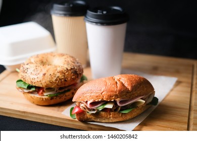 Delicious classic blt sandwiches  bagels with ham, cheese, bacon, tomatoes. Breakfast and fast food meal biodegradable box set with drink on isolated black background wooden and text copy space. - Powered by Shutterstock