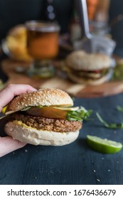 Delicious Closeup Veggie Quorn Burger. At The Back There Is Another Vegan Burger, A Beer Jar, Chips And More.