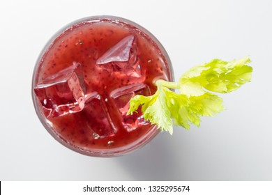 Delicious Cocktail Using Hydrated Chia Seeds And Tart Cherry Juice With Fresh Celery Served On The Rocks Over A White Background