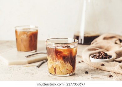 Delicious cold brew coffee with milk in glass on grunge table - Shutterstock ID 2177358697