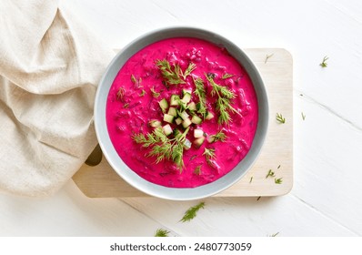 Delicious cold summer beetroot soup with cucumber and dill in bowl over white wooden background. Healthy detox or vegetarian food concept. Top view, flat lay - Powered by Shutterstock