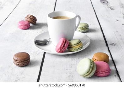 Delicious colorful macarons with cream and coffee cup. Coffee break scene with macaron candy and selective focus. - Powered by Shutterstock