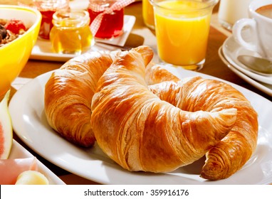 Delicious continental breakfast with fresh flaky croissants, assorted preserves, orange juice , cereal and coffee, close up on the croissants - Powered by Shutterstock