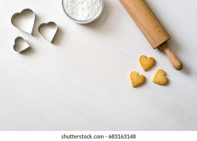 delicious Cookies in heart shape lying after baking decorative with rolling pin and biscuit cutter - Powered by Shutterstock