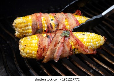 Delicious Corn On The Cob Wrapped In Bacon Over The Bbq Grill Closeup