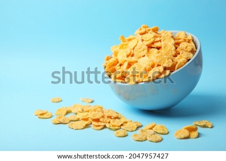 Delicious cornflakes in a plate against colored background. 