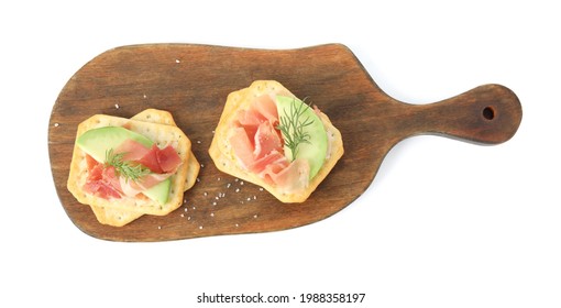 Delicious crackers with avocado, prosciutto and dill on white background, top view