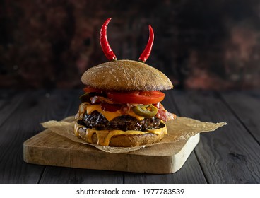 Delicious craft beef burger with jalapenos, cheese, bacon, and whole wheat bun. Copy space.