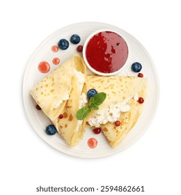Delicious crepes with cottage cheese, jam, redcurrants and blueberries isolated on white, top view