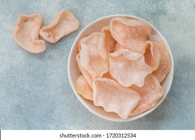 Delicious crispy chips made of starch, flour and shrimp. Bowl of Krupuk (prawn crackers). Traditional Asian snack. A dish of Indonesian, Malaysian, Chinese, Korean, Japanese cuisine. Selective focus