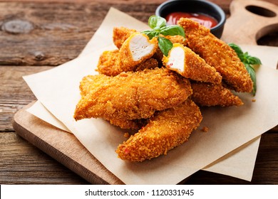 Delicious crispy fried breaded chicken breast strips .
