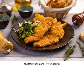 Delicious crispy fried breaded chicken breast strips on restaurant table