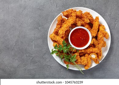 Delicious Crispy Fried Chicken Breast Strips  With Tomato Sauce On White Plate, On Concrete Table, View From Above