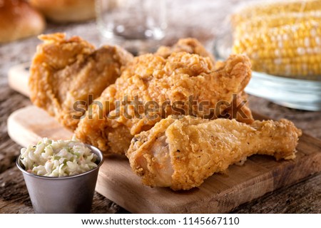 Delicious crispy fried chicken with coleslaw and corn on the cob.