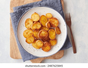 delicious and crispy sliced roasted potatoes on a plate on the table ready to eat. - Powered by Shutterstock