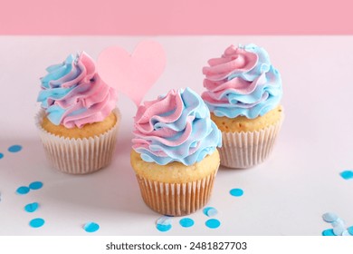 Delicious cupcakes with confetti on table against pink background. Gender reveal party concept - Powered by Shutterstock