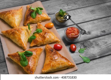 Delicious Deep Fried South Indian Samosa Pies With Meat, Lettuce, Mint Chutney And Tomato Sauce On A Gray Wooden Background In Rustic Style, Empty Place For Text, Recipe