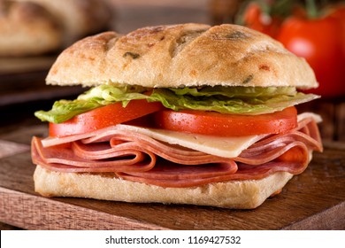 A Delicious Deli Sandwich On Cheddar Jalapeno Ciabatta Bread With Lettuce And Tomato.