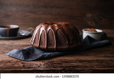 Delicious dessert, dark chocolate bundt cake topped with ganache glaze on rustic wooden background - Powered by Shutterstock