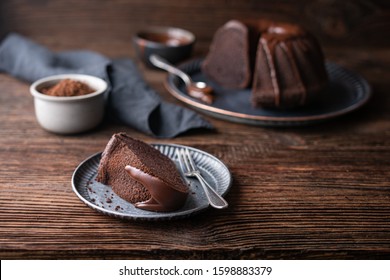 Delicious dessert, dark chocolate bundt cake topped with ganache glaze on rustic wooden background - Powered by Shutterstock