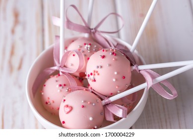 Delicious dessert in milk chocolate in white piala on a wooden background. Cake pops with pink cream - Powered by Shutterstock