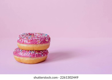 Delicious dessert. Pink donuts with multicolored sprinkles on a pink background of Sweets. Confectionery products. - Powered by Shutterstock