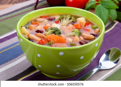 Delicious diet vegetarian soup on the table. Against the background of tomatoes and basil leaves