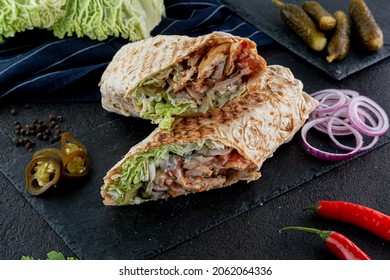 Delicious doner, wrap with meat chicken, shawarma, tasty chicken roll on black wood background