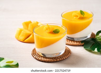 Delicious double colored mango panna cotta mousse pudding with diced mango pulp flesh topping on wooden table background. - Powered by Shutterstock