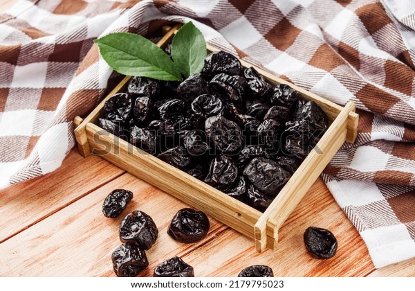 delicious\
dried prunes on a wooden rustic\
background.