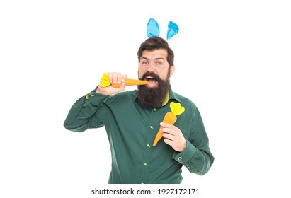 Delicious Easter Treats. Eastertide. Happy Bearded Man Wear Bunny Ears. Happy Easter Carrot. Hipster Wearing Rabbit Ears. Time For Fun. Cheerful Guy Bite Carrots. Spring Holiday Greeting.