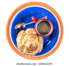 delicious eclair and a cup of coffee on a blue plate isolated on