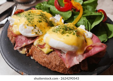 Вкусный бенедикт с ветчиной и свежим зеленым салатом на дисплее