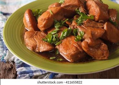 Delicious Filipino Food: Adobo chicken with herbs close-up on a plate on the table. horizontal