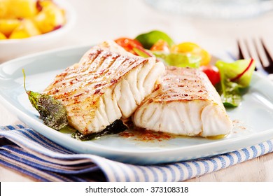 Delicious fillets of pollock or coalfish cooked in a spicy marinade and served with fresh salad and baby potatoes as a seafood appetizer to dinner