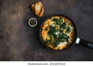 A delicious and flavorful herb omelette is beautifully served in a skillet alongside some toasted bread and spices