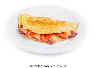 Delicious folded omelette filled with cheese, ham and tomatoes, served on a white plate, isolated on a white background