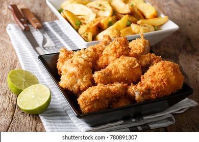 Delicious food: deep-fried chicken wings in breadcrumbs and potato close-up on the table. horizontal