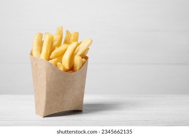 Delicious french fries in paper box on white wooden table, space for text - Powered by Shutterstock