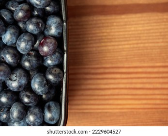 Delicious fresh blueberries in a black container on a wooden table background. close-up. selective focus. free text space. copy space - Shutterstock ID 2229604527