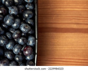 Delicious fresh blueberries in a black container on a wooden table background. close-up. selective focus. free text space. copy space - Shutterstock ID 2229984323