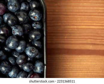 Delicious fresh blueberries in a black container on a wooden table background. close-up. selective focus. free text space. copy space - Shutterstock ID 2231368511