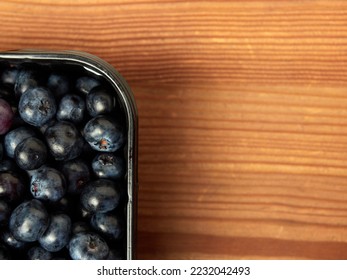 Delicious fresh blueberries in a black container on a wooden table background. close-up. selective focus. free text space. copy space - Shutterstock ID 2232042493