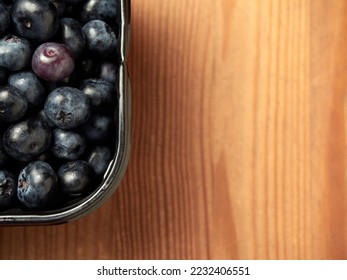 Delicious fresh blueberries in a black container on a wooden table background. close-up. selective focus. free text space. copy space - Shutterstock ID 2232406551